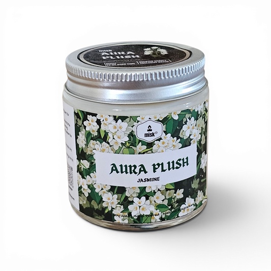 Jar of 'Aura Plush Jasmine' candle with floral design on a white background