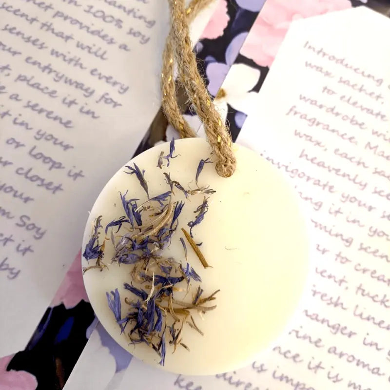 An array of several wax sachets hung upon a decorative tree resembling over the counter display 