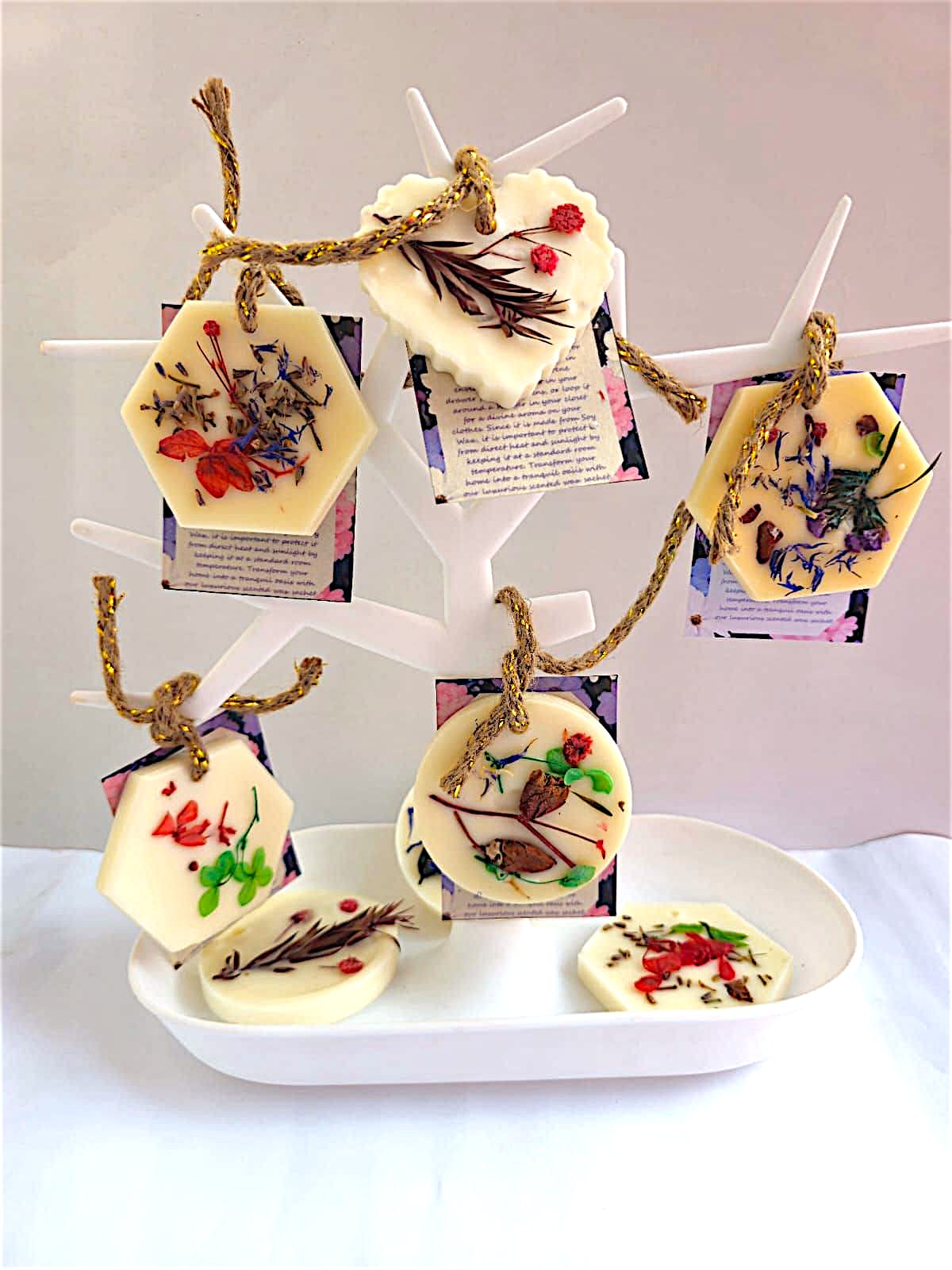 An array of several wax sachets hung upon a decorative tree resembling over the counter display 