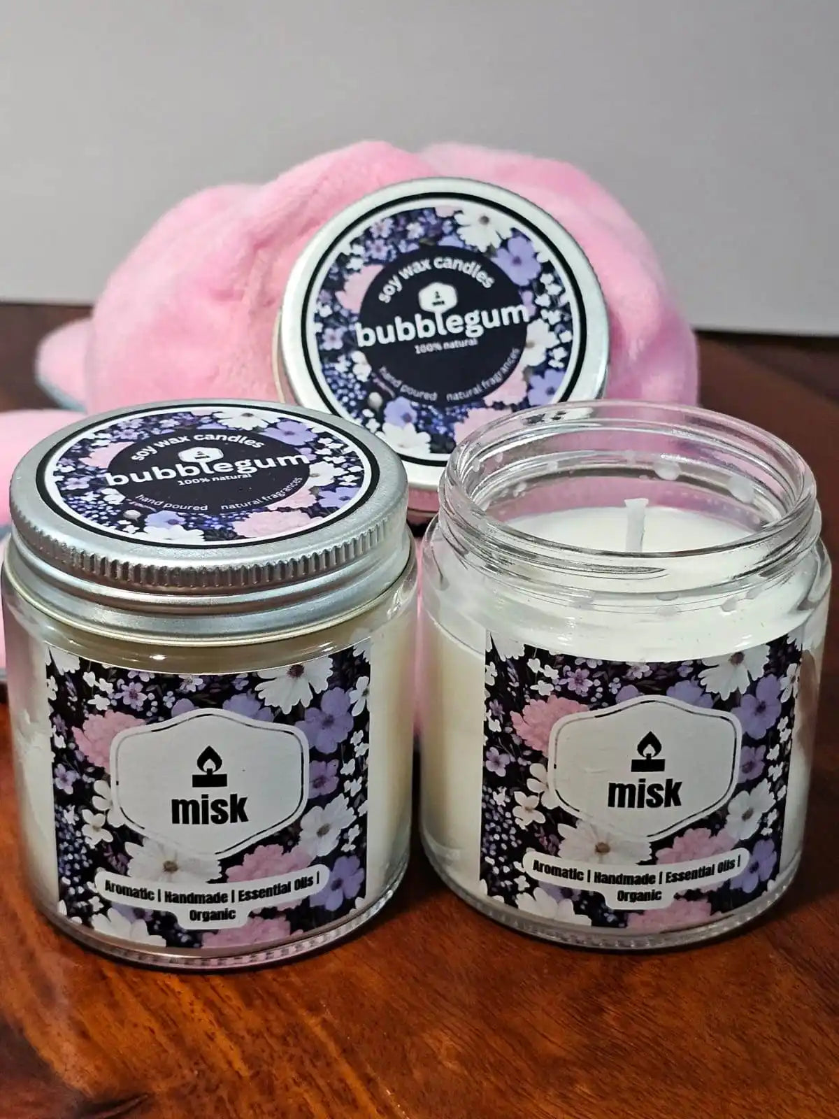 Two jars of 'bubblegum' scented candles with a pink plush toy in the background.