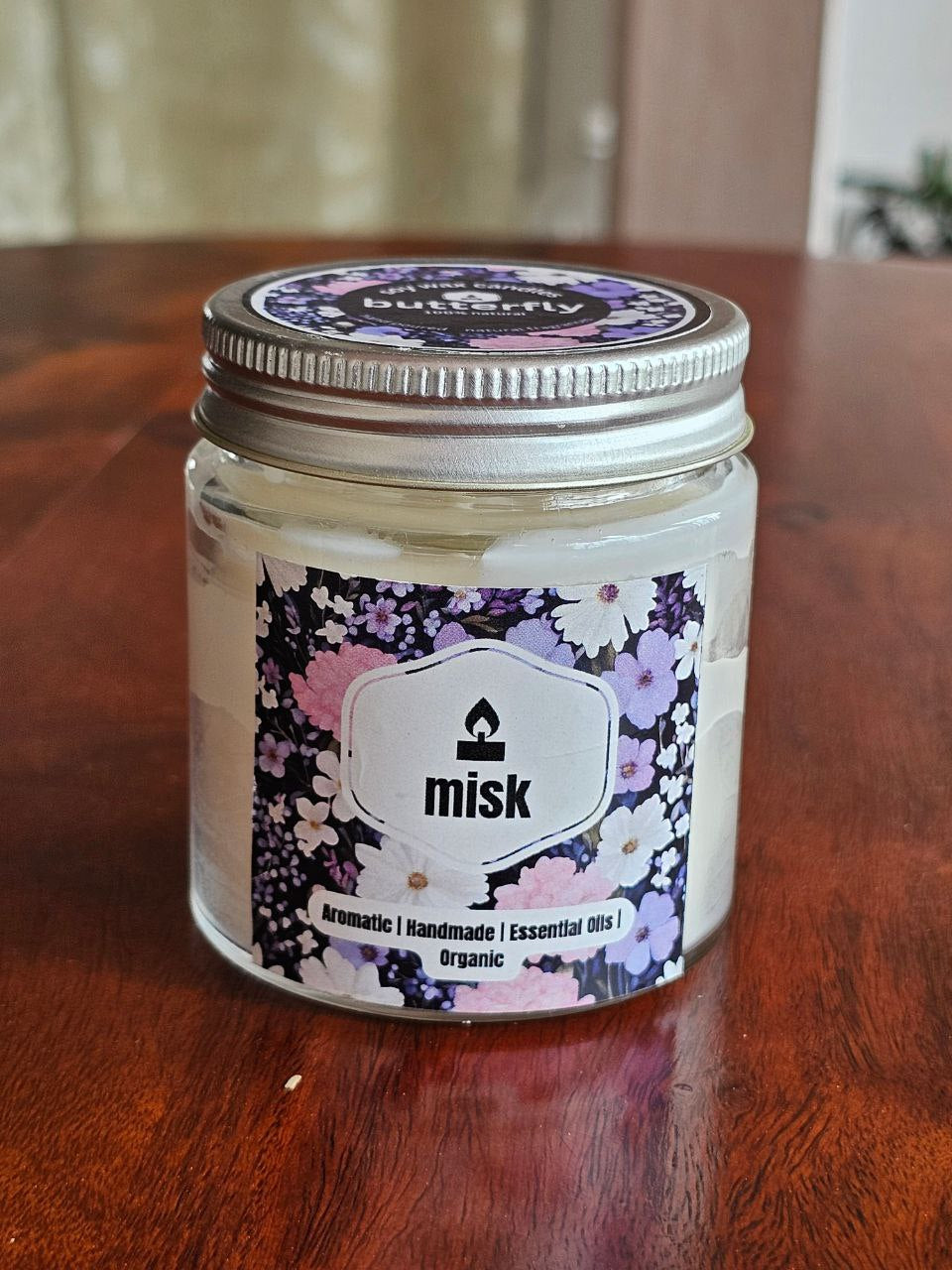 misk Butterfly soy wax candle with jasmine, rose, vanilla notes in a floral jar
