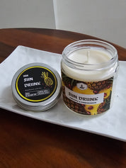 Su. Drunk candle on a tray over a tabletop. Lid is open