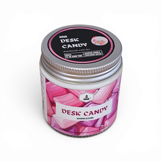 Desk Candy candle in a pink jar with a silver lid on a white background
