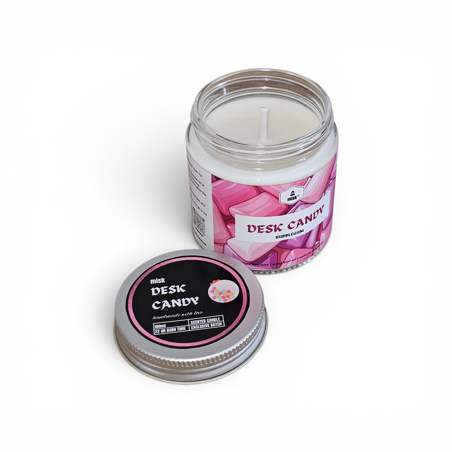 Desk candy candle with pink label and black lid on a white background